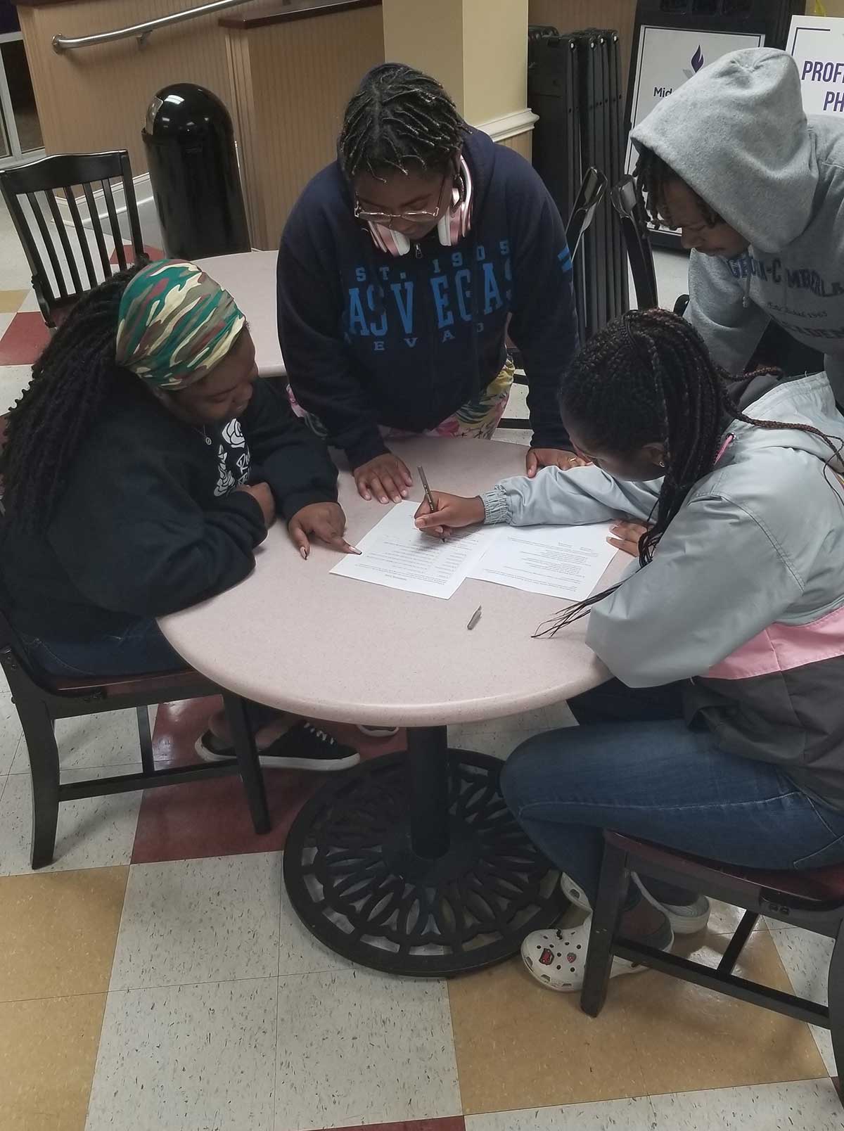Students solving a group trivia sheet.